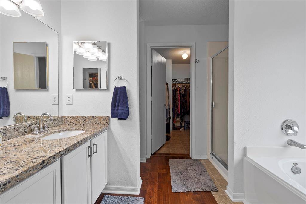Your primary bath is a serene retreat, combining comfort and functionality with a dual-sink vanity for effortless morning routines. Thoughtfully designed built-in medicine cabinets on both sides provide extra storage, keeping essentials within reach. A spacious walk-in shower offers convenience, while a separate soaking tub creates the perfect spot to unwind and relax.