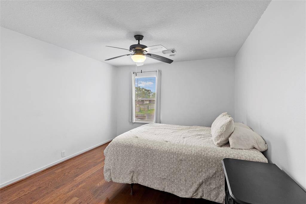 From this angle, your secondary bedroom highlights its spacious and inviting feel. Large windows fill the room with natural light, enhancing the warm and cozy ambiance.