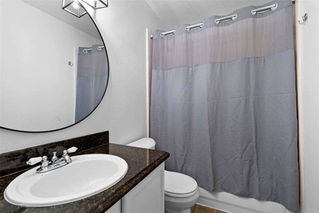 Your secondary bath is a well-appointed space designed for both comfort and convenience. It features a sleek vanity with ample storage, a tub/shower combo with a tiled surround, and bright lighting that enhances the refreshing and functional atmosphere, making daily routines effortless.