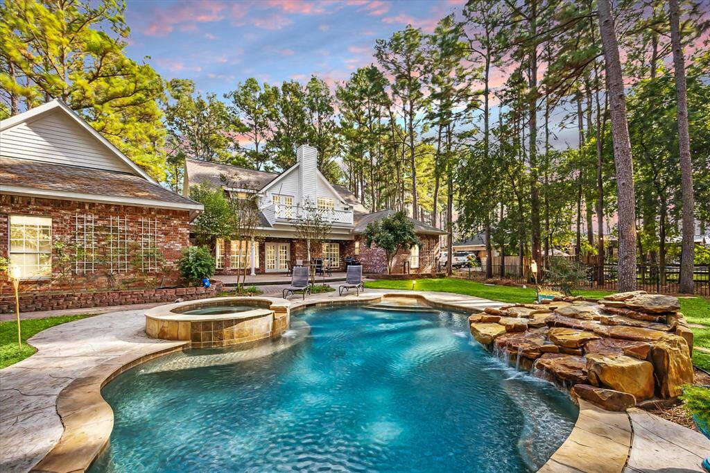 Stunning view of the four-sided brick home and glistening pool