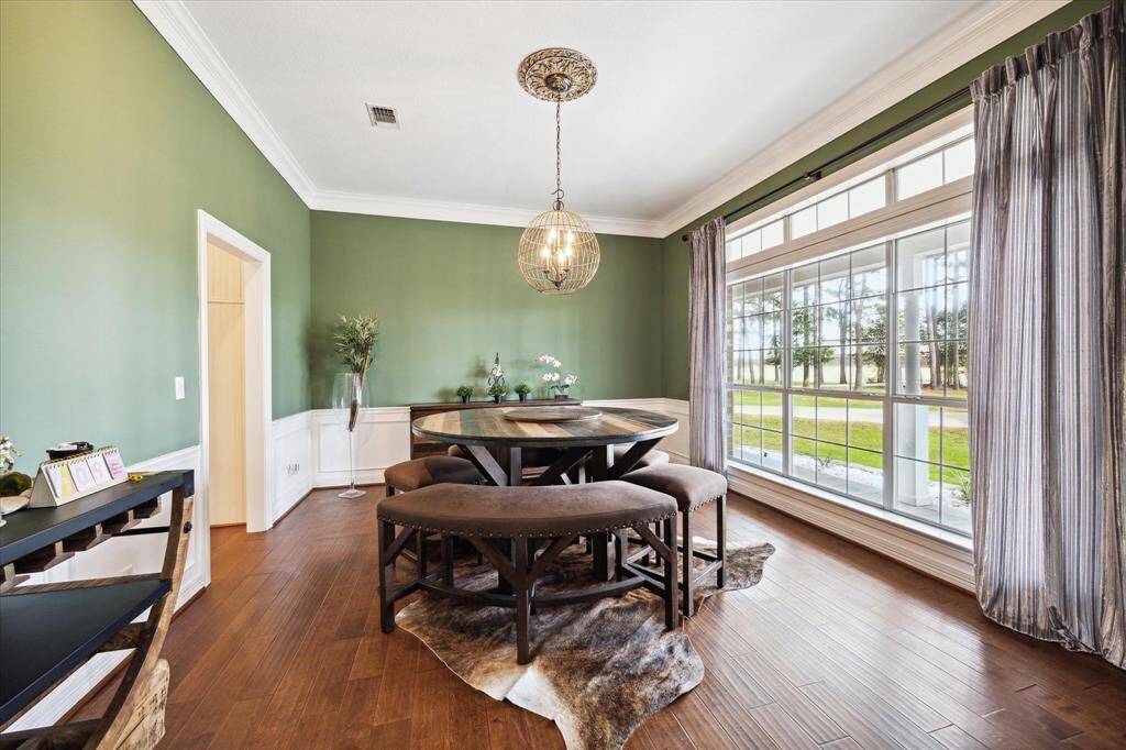 To the right, the formal dining room is perfect for hosting gatherings, with the gleaming wood floors reflecting the natural light
