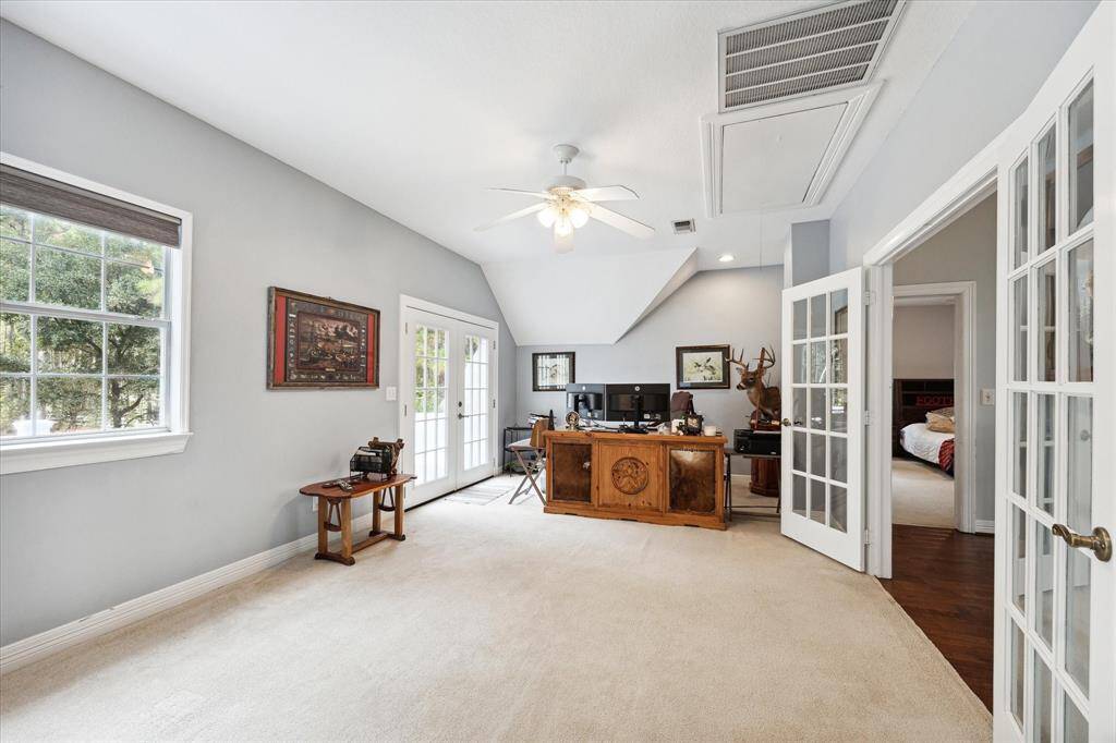 The second floor offers a versatile game room accessed through a set of elegant double doors