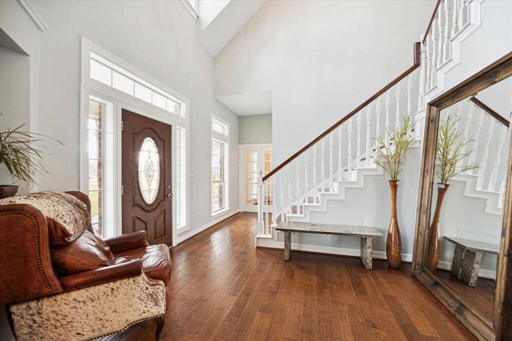 As you step through the front door, you're greeted by the warmth of the wooden floors throughout the home