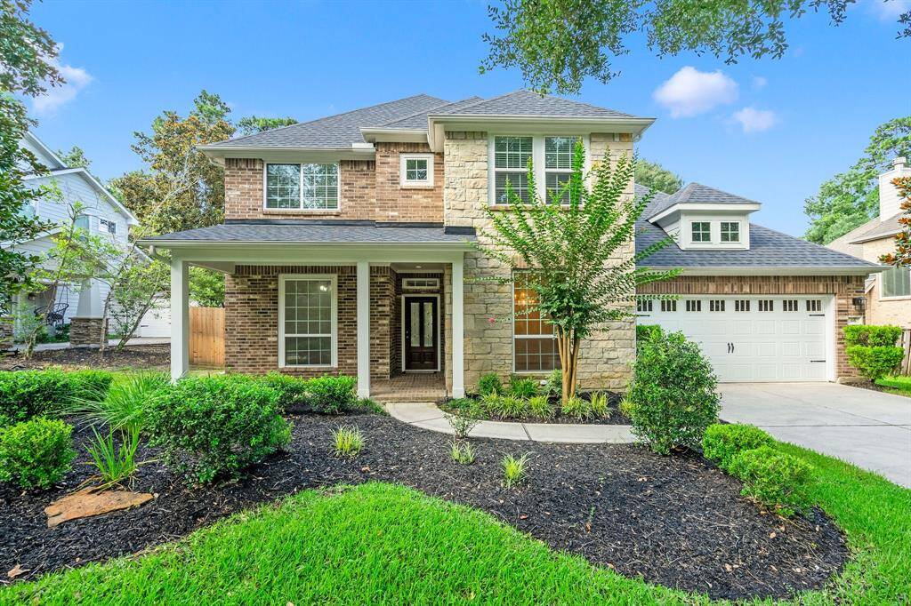 This charming two-story home features a classic brick and stone facade, a welcoming front porch, and a neatly landscaped front yard. The attached two-car garage offers convenience, and the property is surrounded by mature trees, adding to its curb appeal.