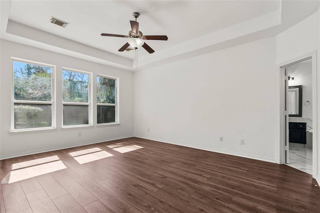 Spacious ground-level master bedroom with abundant natural light and direct access to an en-suite bathroom.