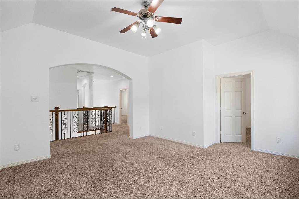 Inviting Upper-Level Family Retreat with Plush Carpeting and Elegant Iron Railing