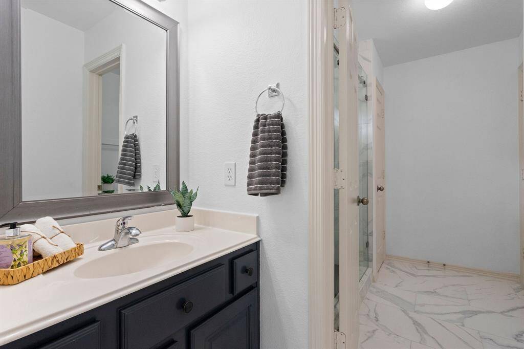 Ensuite Dual-Access Bathroom - Upper Level: Features elegant marble flooring and modern fixtures for a seamless morning routine.