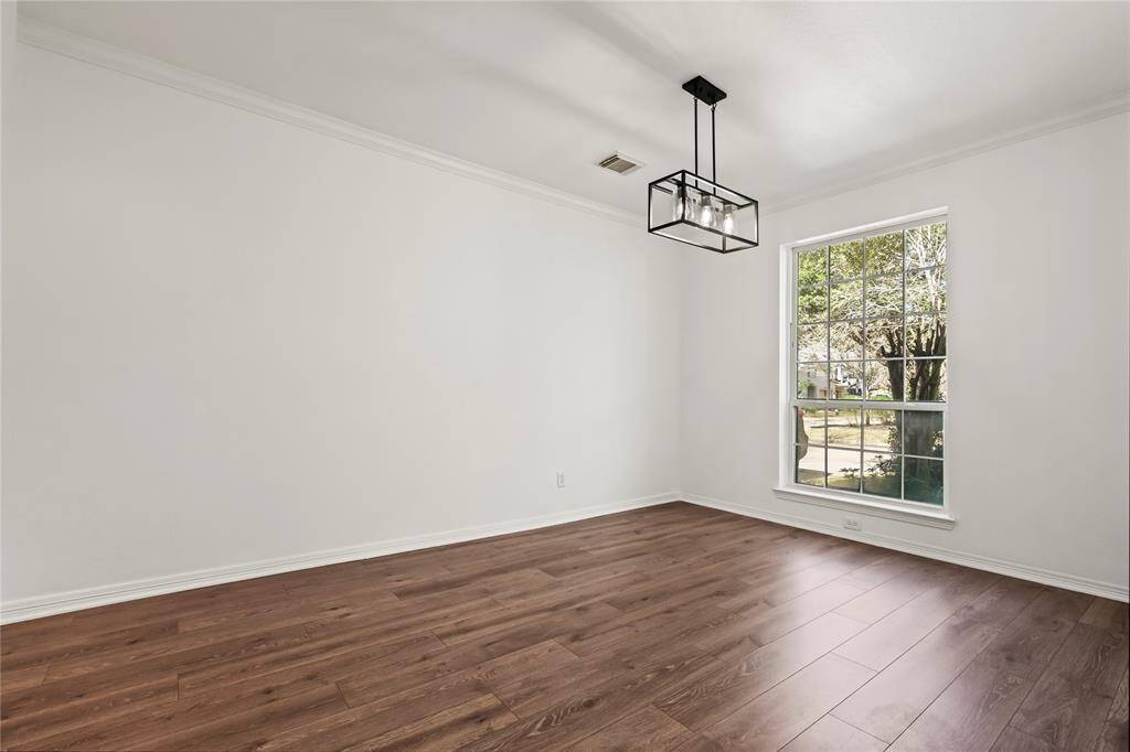 Inviting ground-level dining room with abundant natural light and elegant chandelier.