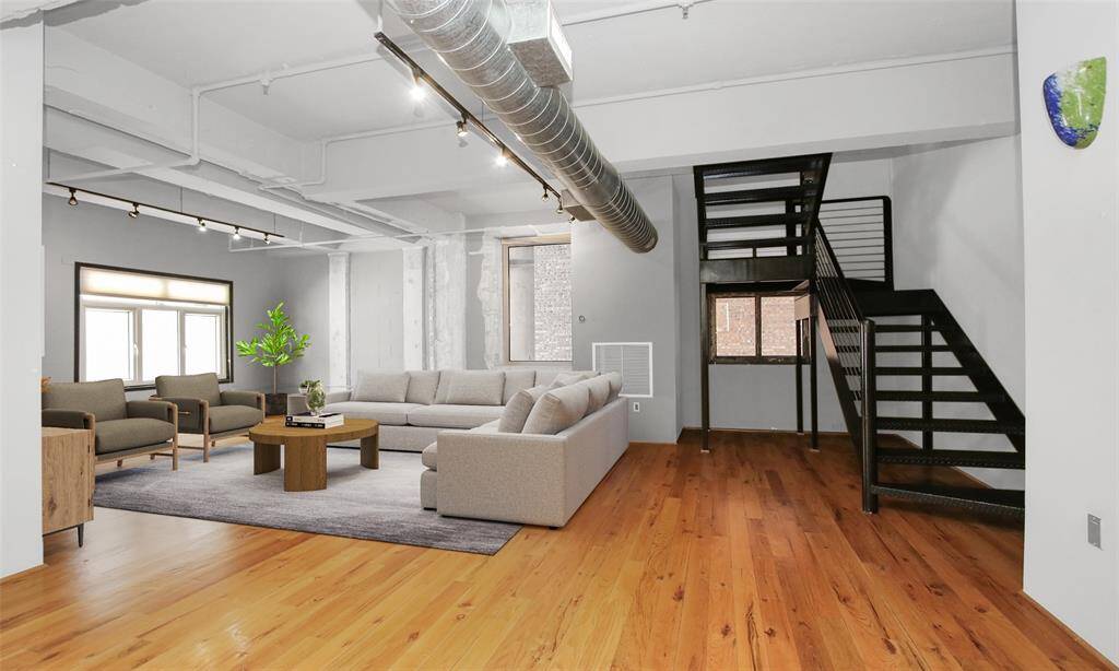 Open ceilings, exposed ductwork, track lighting, concrete columns, and brick accents create a true loft vibe defining the urban lifestyle. This photo has been virtually staged and digitally color enhanced.