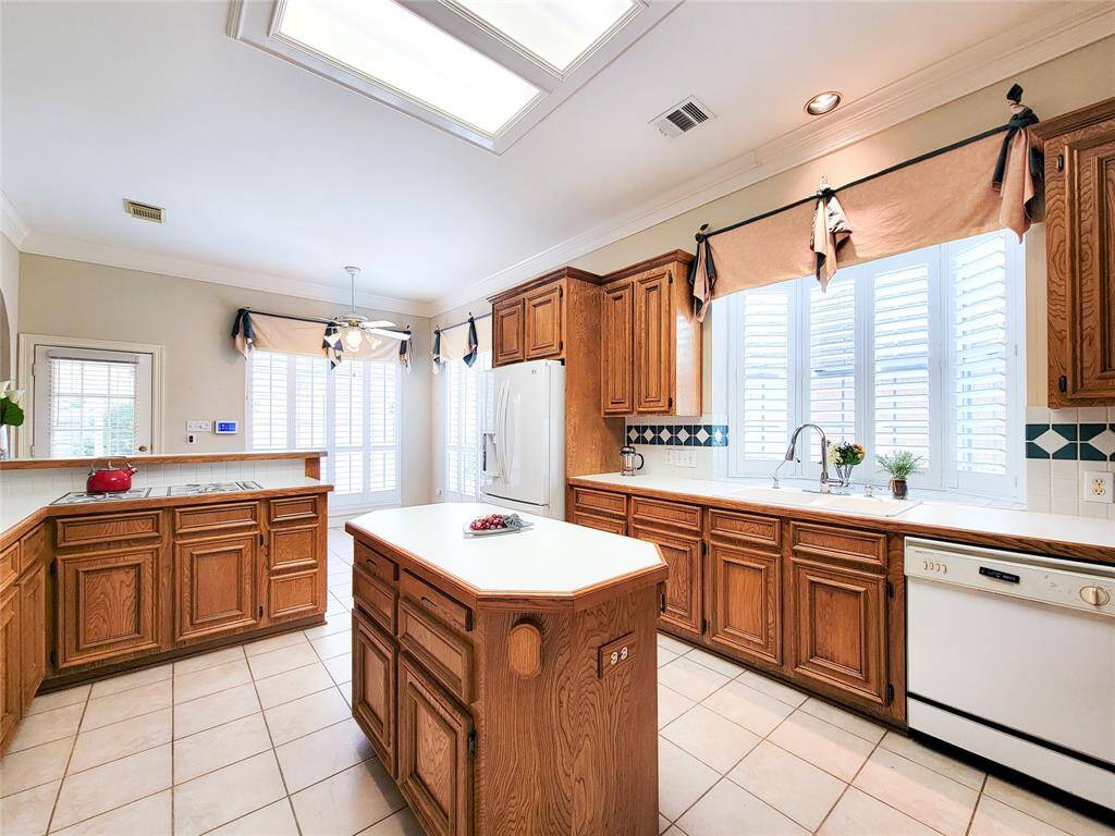 Flowing island Kitchen with solid wood cabinetry, cabinet pull-outs, lazy-susan corner cabinet, bar for eating- a view looking from dining room towards back door.