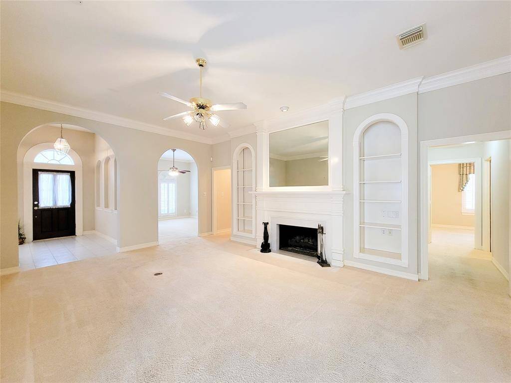Living Room view-stately presence with archways, crown molding, custom millwork & built-in's, gas log fireplace, & plush carpet