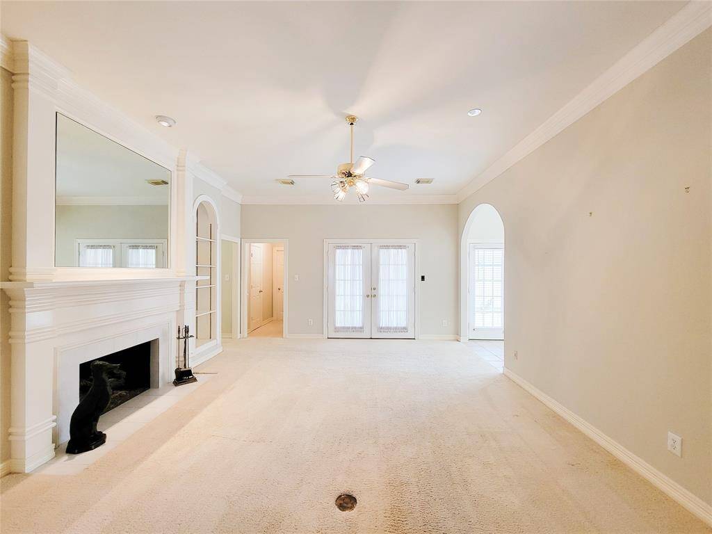 Living Room view looking towards patio with hallway that leads to Powder Room & Primary Suite