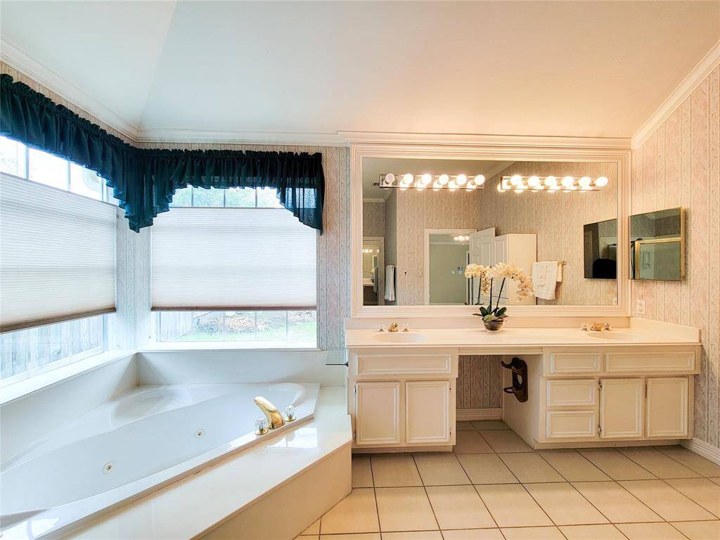 White Primary En-Suite Bath has double sink vanity, large oval jacuzzi tub & glass enclosed shower