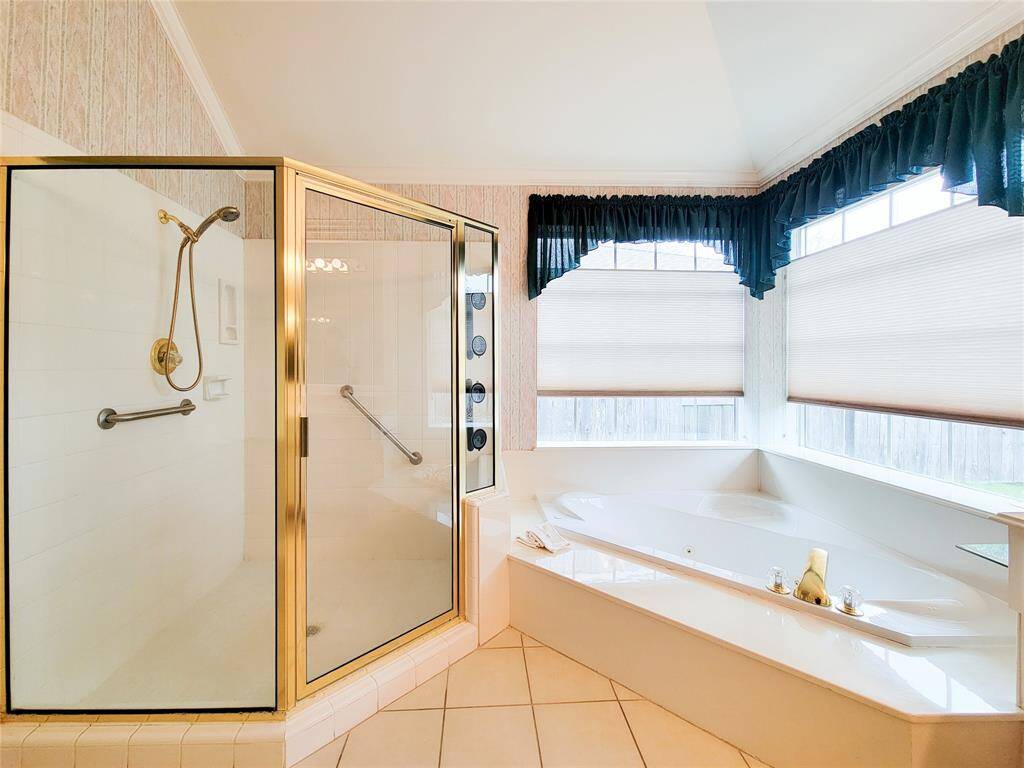 Large shower with new white tile & oval jacuzzi tub for relaxation