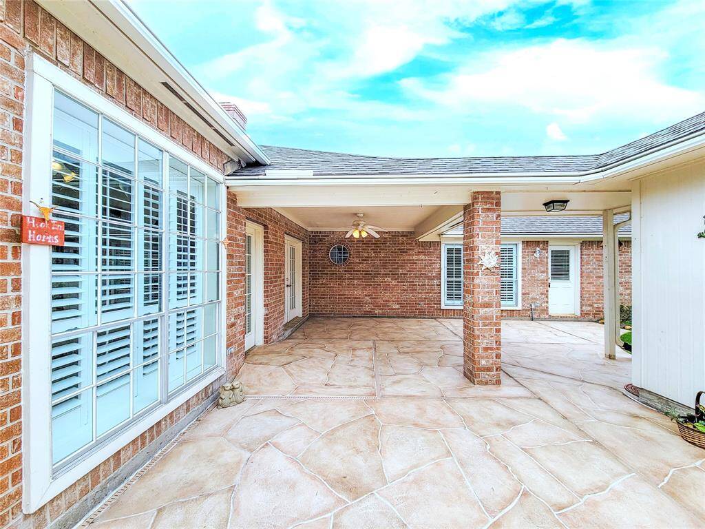 View of large covered Patio & back of house from driveway, new stamped concrete. Ready for Summer entertaining.