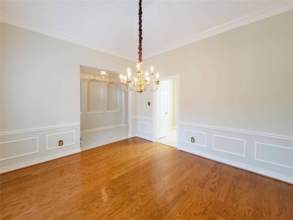 Dining Room looking towards front entry, Living Room & kitchen opening, gleaming hardwood floors, block wainscoat paneling