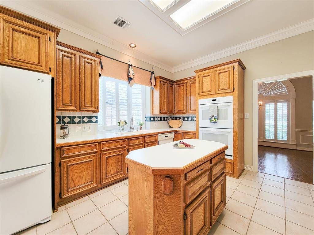 Another view of bright Island Kitchen ready for meal prep & gatherings. Custom solid wood cabinetry with soft close & pull-outs, peeping to the Dining Room, Bay window extending out beyond kitchen sink.