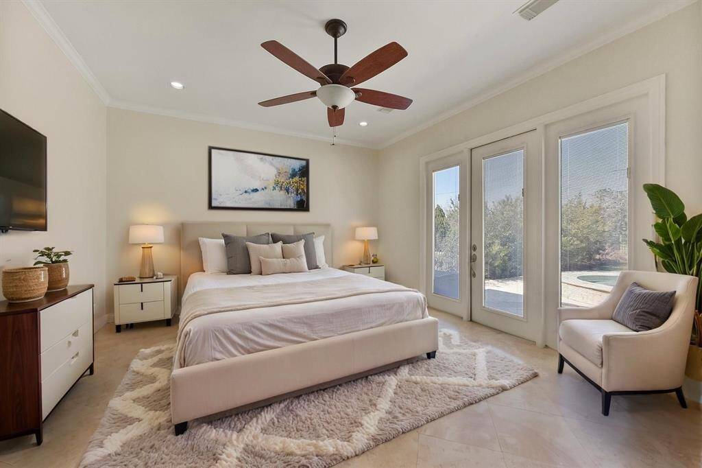 SPACIOUS PRIMARY BEDROOM WITH CROWN MOLDING, NATURAL LIGHT, AND DIRECT ACCESS TO THE BACKYARD OASIS. **This room has been virtually staged.