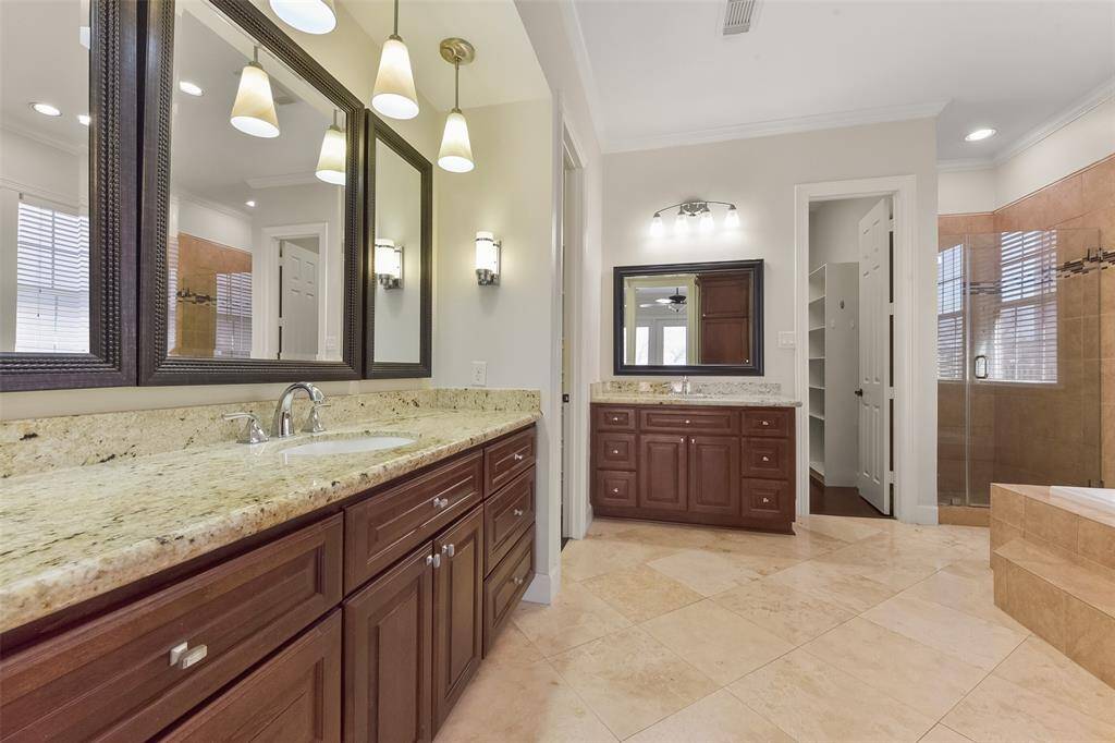 SPA-LIKE MASTER BATHROOM FEATURING A LARGE SOAKING TUB AND SEPARATE GLASS-ENCLOSED SHOWER.