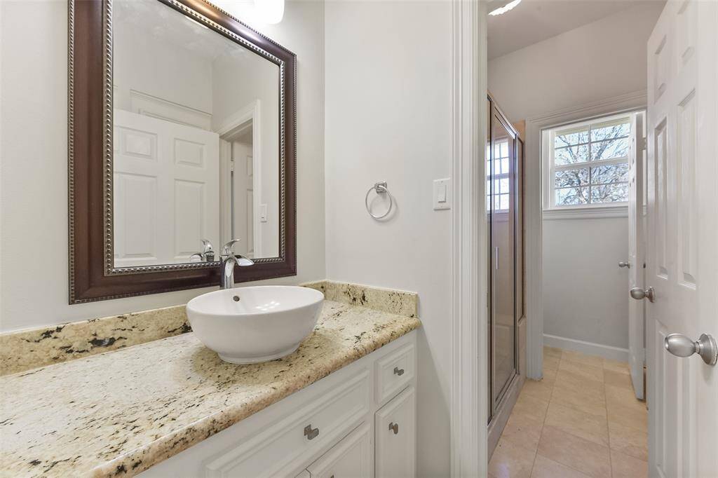 BEAUTIFULLY UPDATED SECONDARY BATHROOM SHOWCASING THE GRANITE COUNTERTOP WITH A STYLISH VESSEL SINK.
