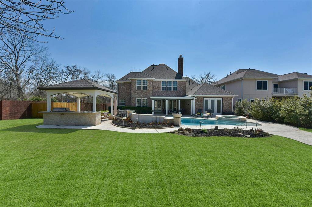 THIS OUTDOOR LIVING AREA OFFERS A LUXURIOUS RESORT-LIKE EXPERIENCE WITH A POOL, SPA, AND ENTERTAINMENT SPACE.
