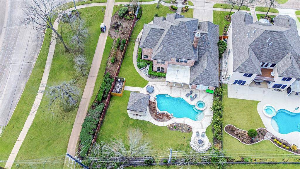 THIS STUNNING BACKYARD OASIS FEATURES A SPARKLING POOL, SPA, AND COVERED PATIO, PERFECT FOR OUTDOOR RELAXATION AND ENTERTAINING.