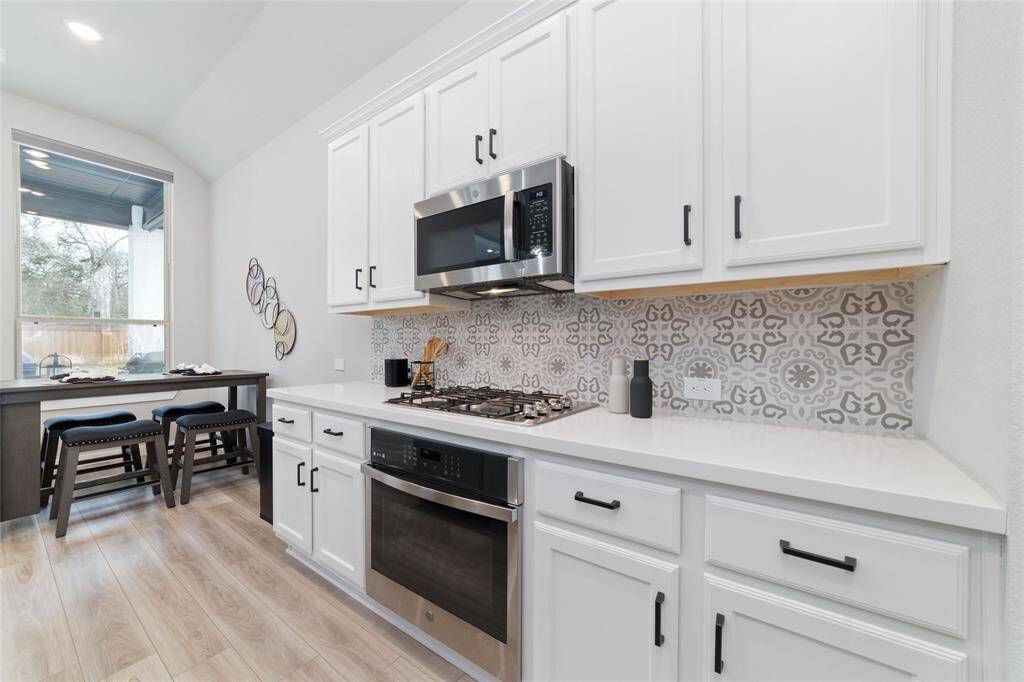 Stunning backsplash adds flair to this gorgeous kitchen that offers plenty of counter space for prepping and serving.