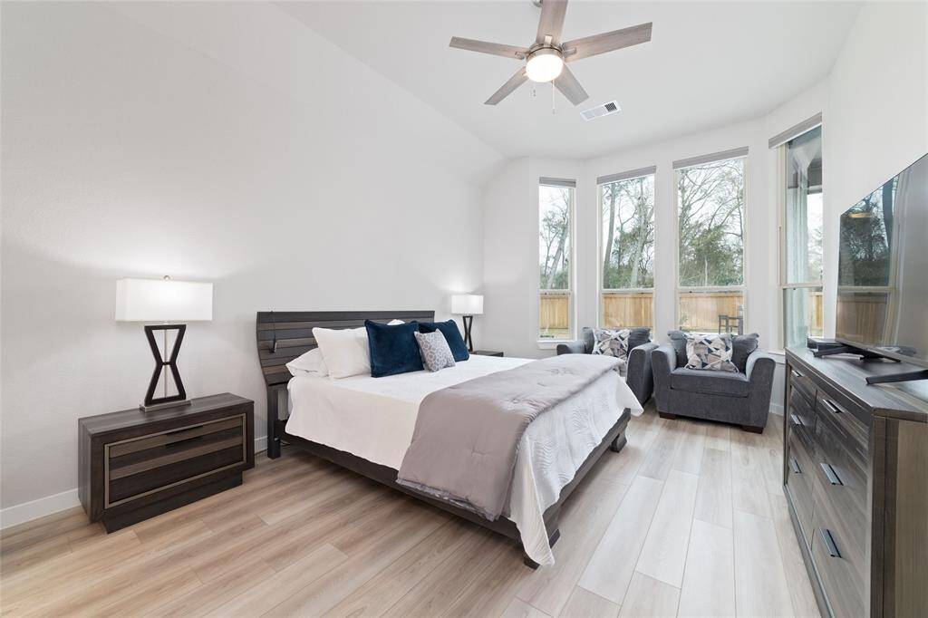 Tall beautiful windows set the stage for the primary bedroom.  You can enjoy looking out at the pool from the comforts of your bed.