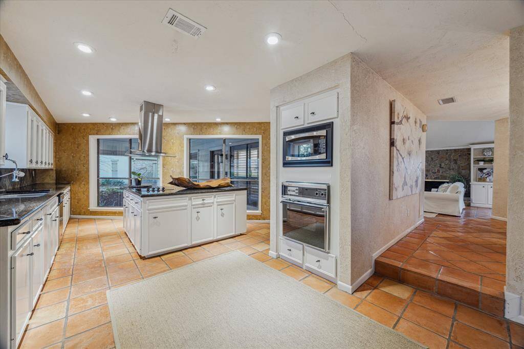 This kitchen view shows the walls of windows and proximity to formal dining room.