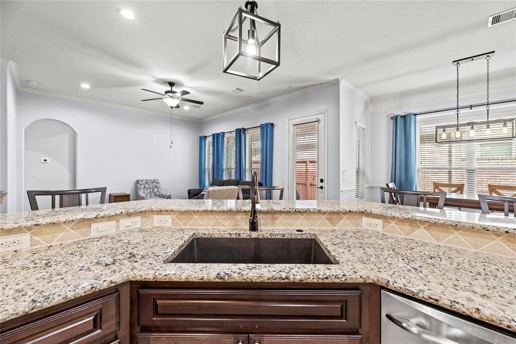 This spacious kitchen features an extended bar with granite countertops, seamlessly connecting to the family and dining areas. The open-concept design allows you to mingle with guests while preparing meals, ensuring you never miss a moment of the conversation.