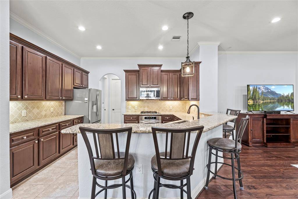 Ditch the takeout and enjoy home cooked meals more often! This fully loaded kitchen is ready to assist with granite countertops, tile backsplash, under-cabinet lights, sleek stainless-steel appliances, and a large walk-in pantry.