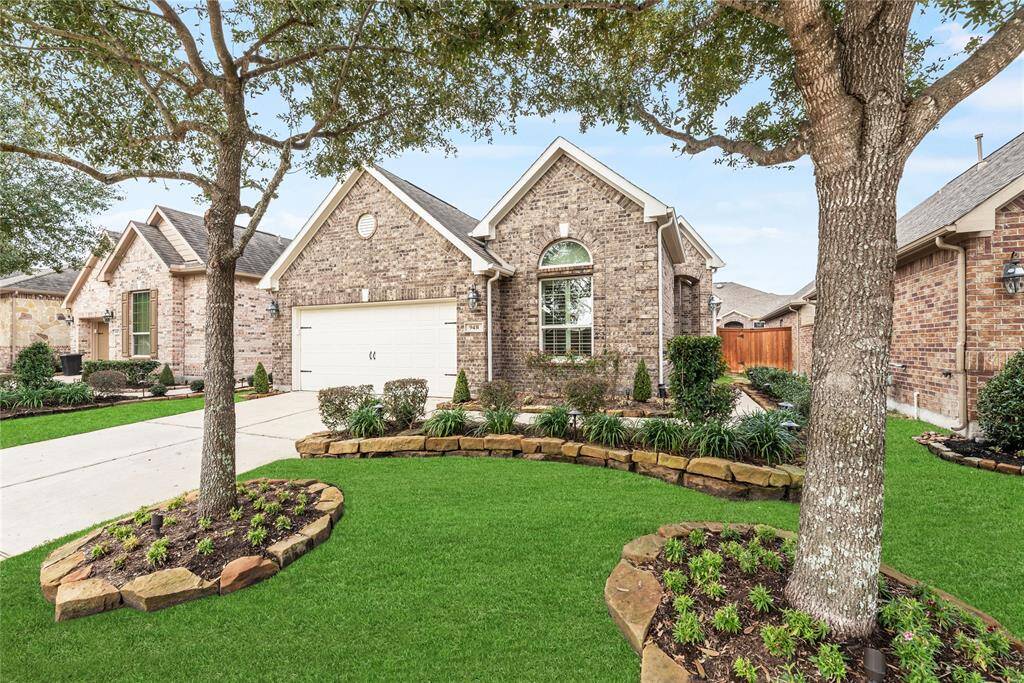 Outstanding curb appeal features a classic brick elevation, a private side entry, and a two-car attached garage. Rock-lined flower beds with mature landscaping and landscape lights offer a warm welcome home every time.