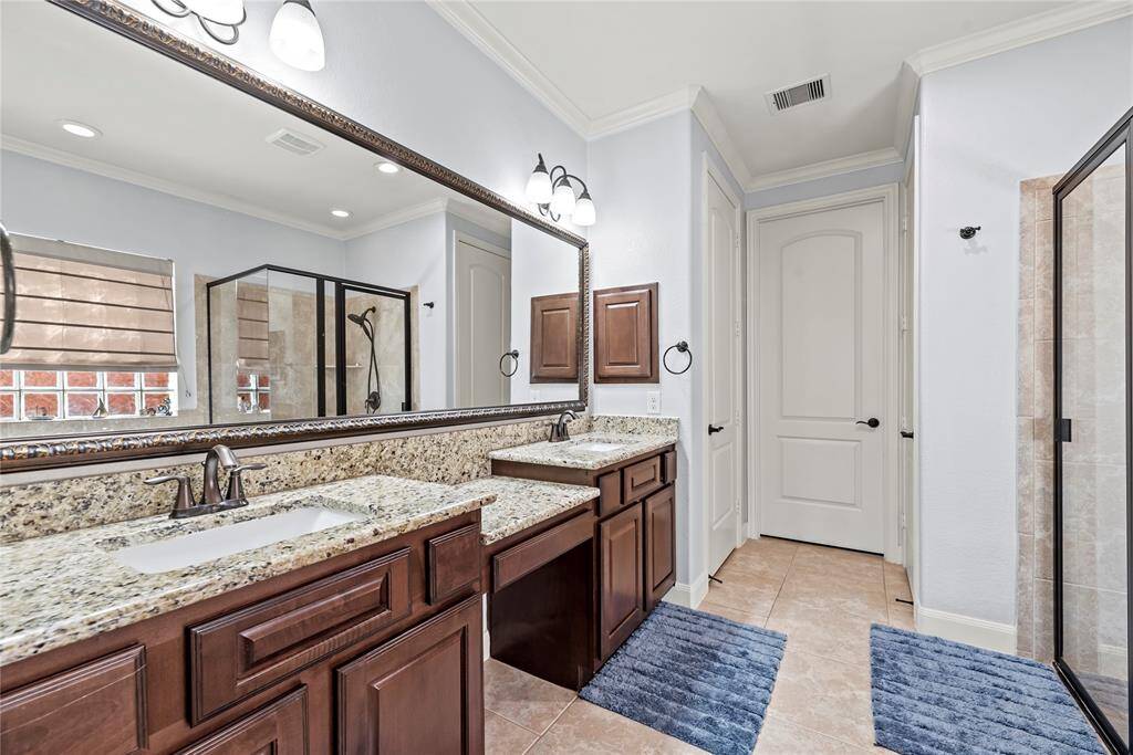 This spotless ensuite bathroom has everything you need to prepare for the day ahead or unwind in the evening. It features an extended dual sink vanity, a private water closet, a walk-in shower, a relaxing jetted tub, and convenient linen storage for effortless organization.