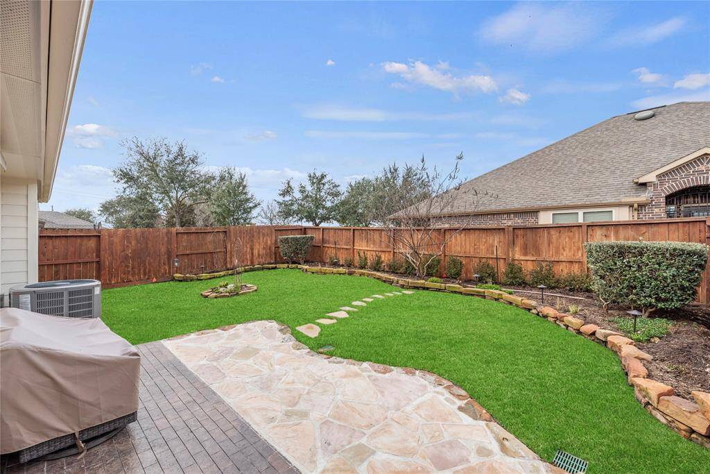 Mature landscaping and a lush, grassy lawn with a full sprinkler system perfectly complement the covered patio and flagstone extension. This is an inviting setting to relax and enjoy fresh air, sunshine, and nature.