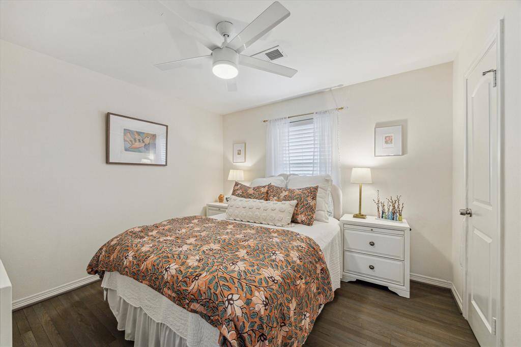 This is one of the secondary bedrooms.  Such a peaceful retreat with soothing neutral paint, beautiful wood floors, a walk in closet and ceiling fan.