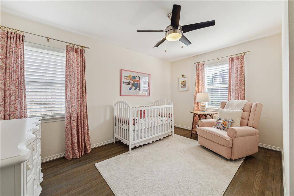 This corner bedroom has abundant natural light from the two windows.  Beautiful original wood floors, ceiling fan, and closet (not pictured) are present here.