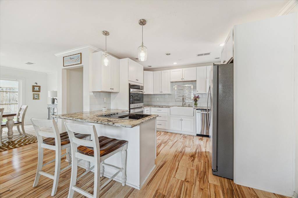 The pristine kitchen has abundant cabinetry, stainless steel appliances and a breakfast bar that is perfect for casual dining or buffet style serving.