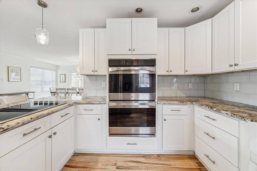 Attractive and durable granite countertops adorn this pretty kitchen. On the left is the smooth cooktop with downdraft.  This kitchen sparkles!