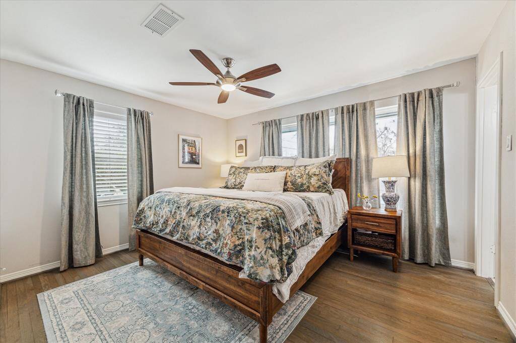 The primary suite has a wall of windows overlooking the pool. The door on the right leads to the ensuite bathroom. A large, custom walk in closet is to the left and not pictured here.