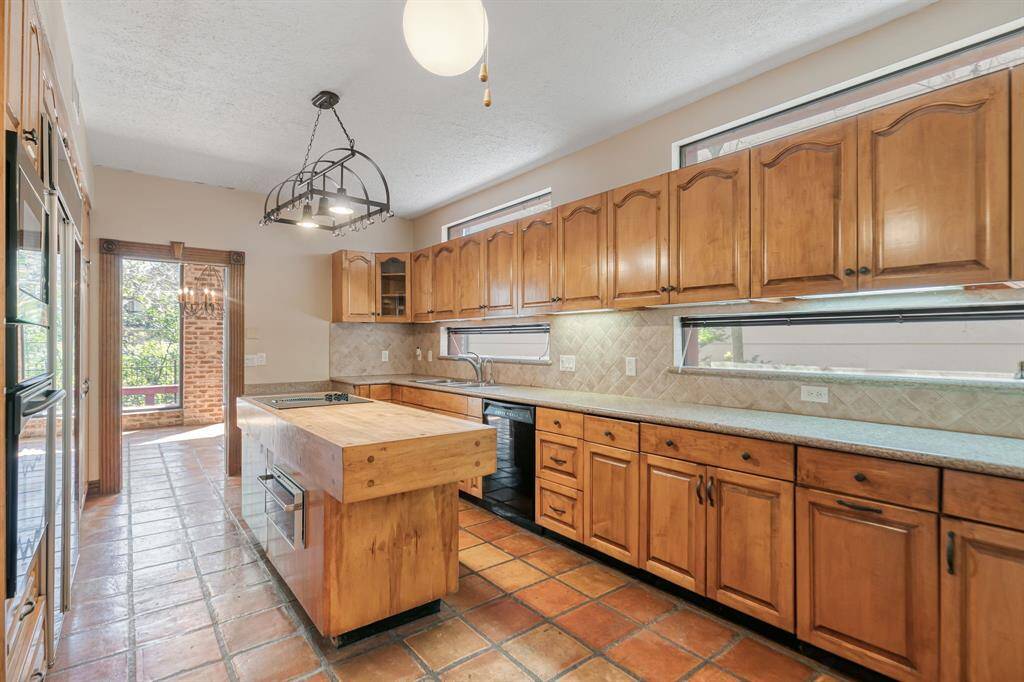a chefs dream kitchen with unbelievable built-ins butcher block center island with a cooktop and a warming drawer
