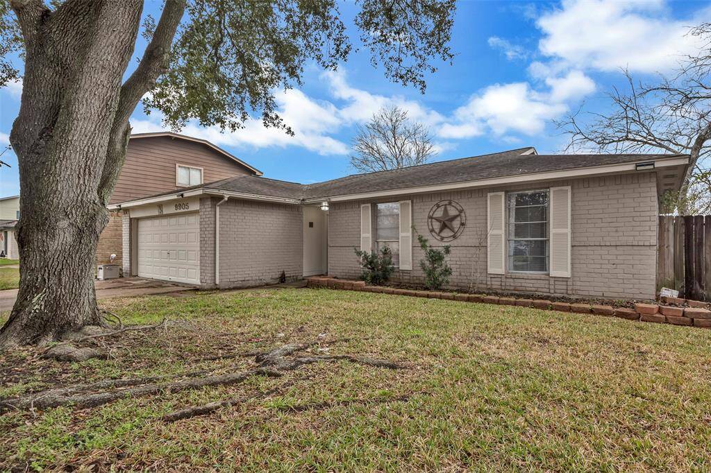 This is a charming single-story home with a light gray brick exterior, featuring a two-car garage.
