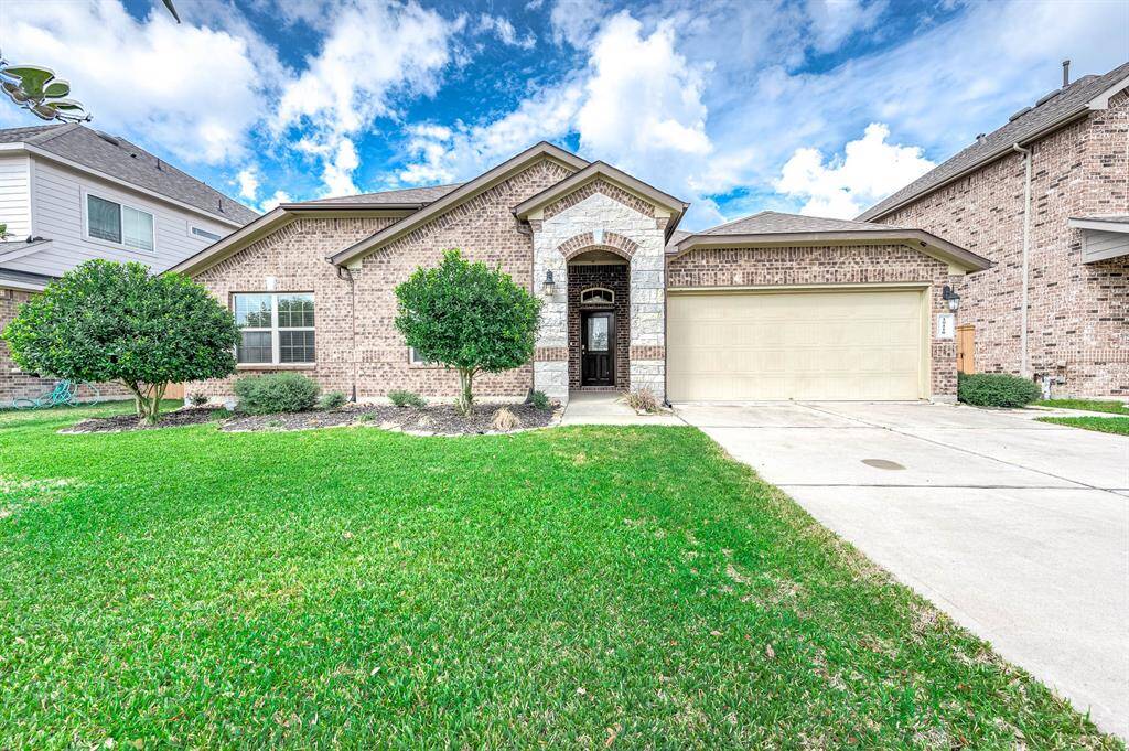 This is a charming single-story brick home with a neat, landscaped front yard. It features a welcoming arched entrance and a spacious three car tandem garage.