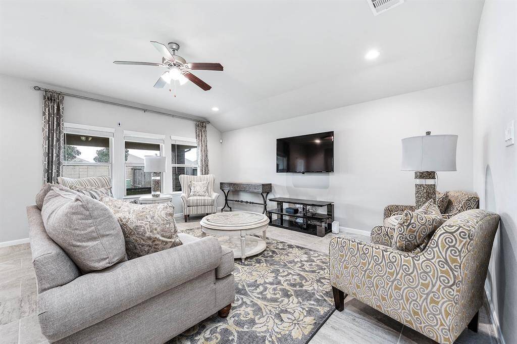 This family room offers a cozy and relaxing atmosphere with large windows for natural light.
