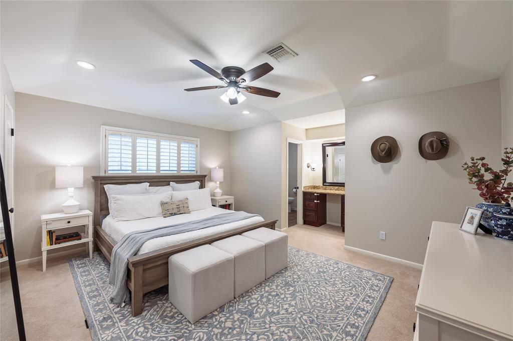 Serene primary bedroom features two closet spaces, an updated ensuite, and vanity area.