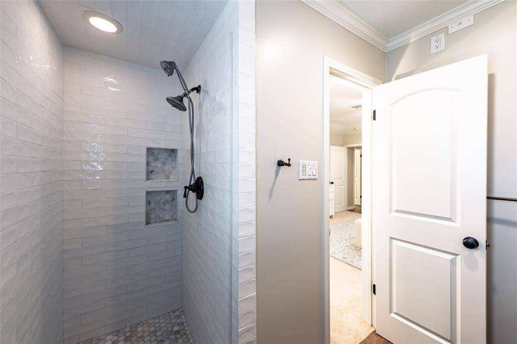 Updated primary shower with built-in storage and gorgeous accent tiles.