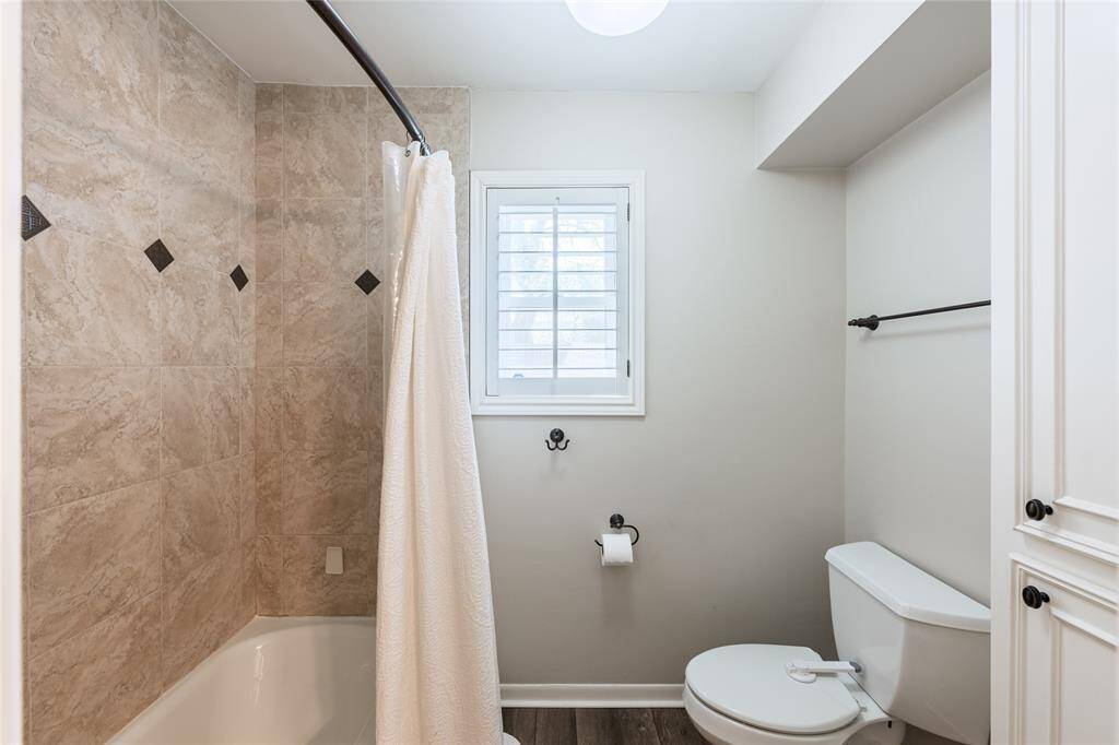 Hall bath with shower/tub combination and additional storage.