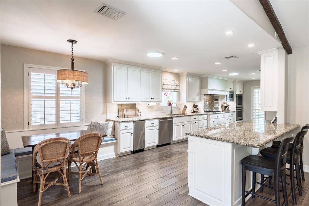 Phenomenal kitchen features Monogram appliances, double ovens, built-in fridge, ice maker, wine fridge, pots & pans drawers, soft-close cabinetry, 5 burner gas cooktop, and dreamy banquette seating in the breakfast nook.