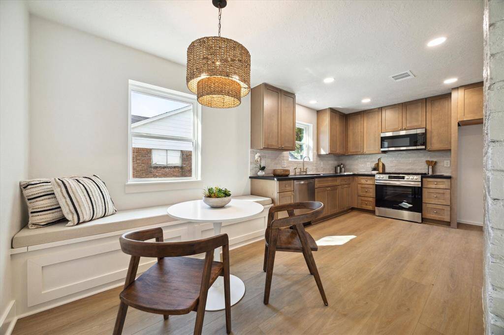 THE BREAKFAST AREA OPENS UP TO THE GOURMET KITCHEN WITH KARMEL CABINETS AND GORGEOUS ABSOLUTE BLACK GRANITE COUNTER.