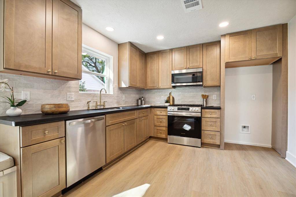 THE KITCHEN IS WELL EQUIPPED WITH STAINLESS STEEL APPLIANCES AND TRENDY SUBWAY BACK-SPLASH.