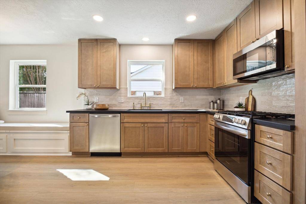 THE LVP FLOORING COMPLIMENTS THE KARMEL KITCHEN CABINETS.